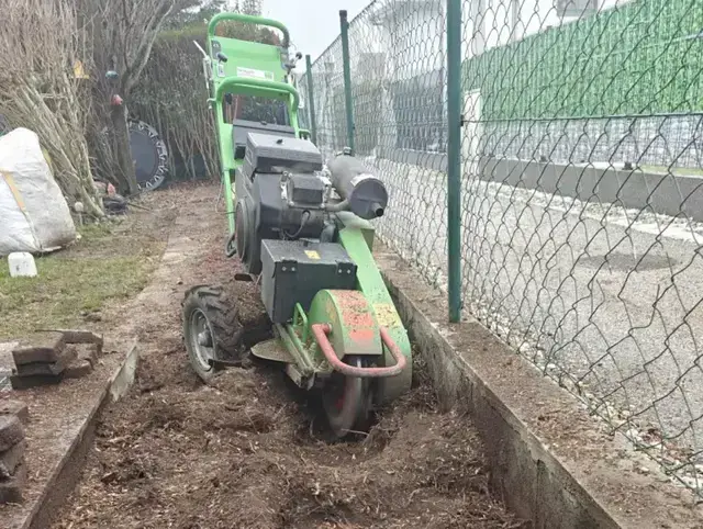 Wurzelstockfräse beim Entfernen von Wurzelwerk im Garten